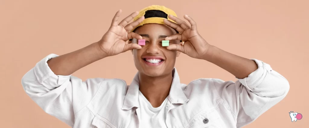 An African teenager is holding the chewing gums infront of his eyes in a fun way | Source: shutterstock | For the article: Surprising Benfits of Chewing Gum for Oral Health | For the website: healthchewinggum.com (Health Chewing Gum)