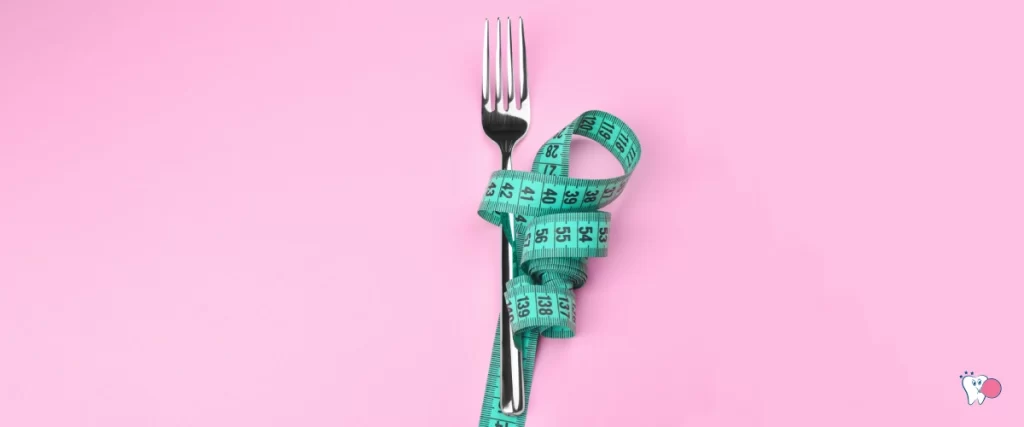 Photo of a fork with a tape measure wrapped around it on a pink background for the article Effective Diet, source: shutterstock, article: Effective Diet, for the website: Health chewing gum (healthchewinggum.com)