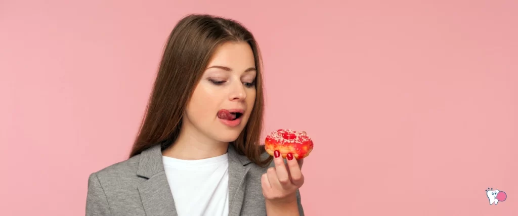 A Bright white girl is tempted to eat a sweet treat while being concious of her weight | Source: shutterstock | For the article: Can chewing Gum help manage appetite? | For the website: healthchewinggum.com (Health Chewing Gum)